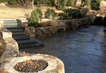 A gas fire pit, and built in stairs leading to the rest of the landscape complete this gorgeous natural stone patio