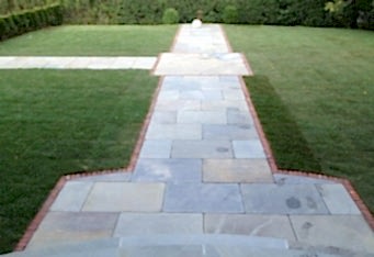 Custom Blue Stone Walkway surrounded by green grass in a landscape designed by GA Landscape Design