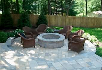 Custom Fire Pit with seating complete this backyard landscape design in Clinton NJ