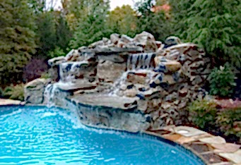 Custom Waterfall into a pool surrounded by large plantings in this Scotch Plains NJ backyard