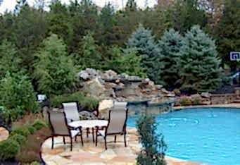 A Waterfall into a pool in this Scotch Plains NJ landscaped backyard